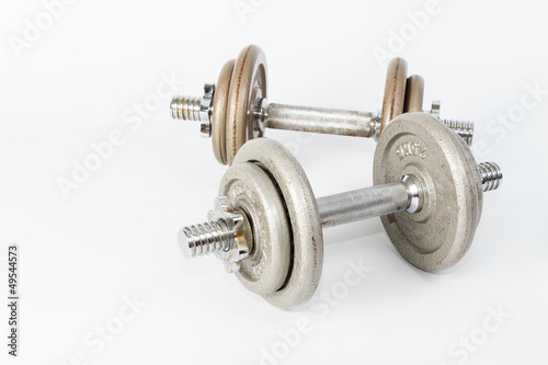 Silver metal dumbbells, one on another isolated on white