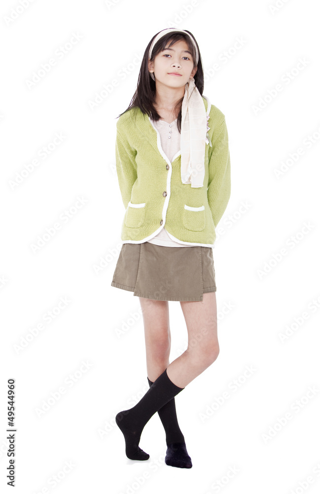 Unsmiling confident young girl in green sweater standing, isolat Unsmiling confident young girl in green sweater standing, isolat