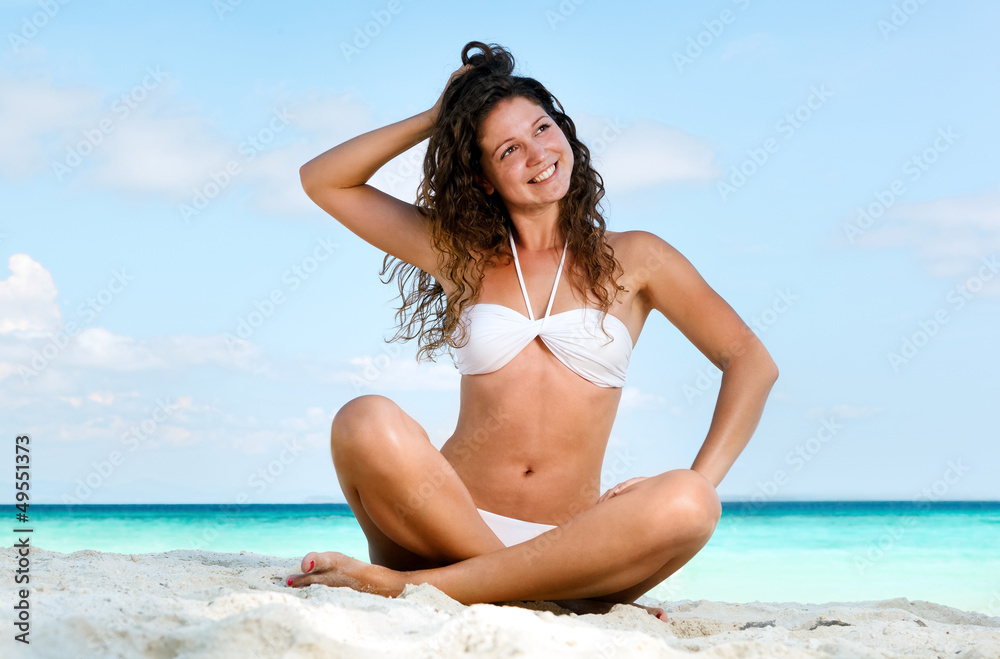 Naklejka premium Portrait of a happy young woman posing while on the beach