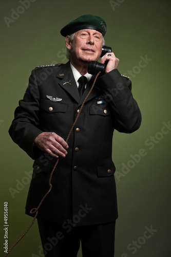 US military general wearing beret. Calling with phone. Studio po photo