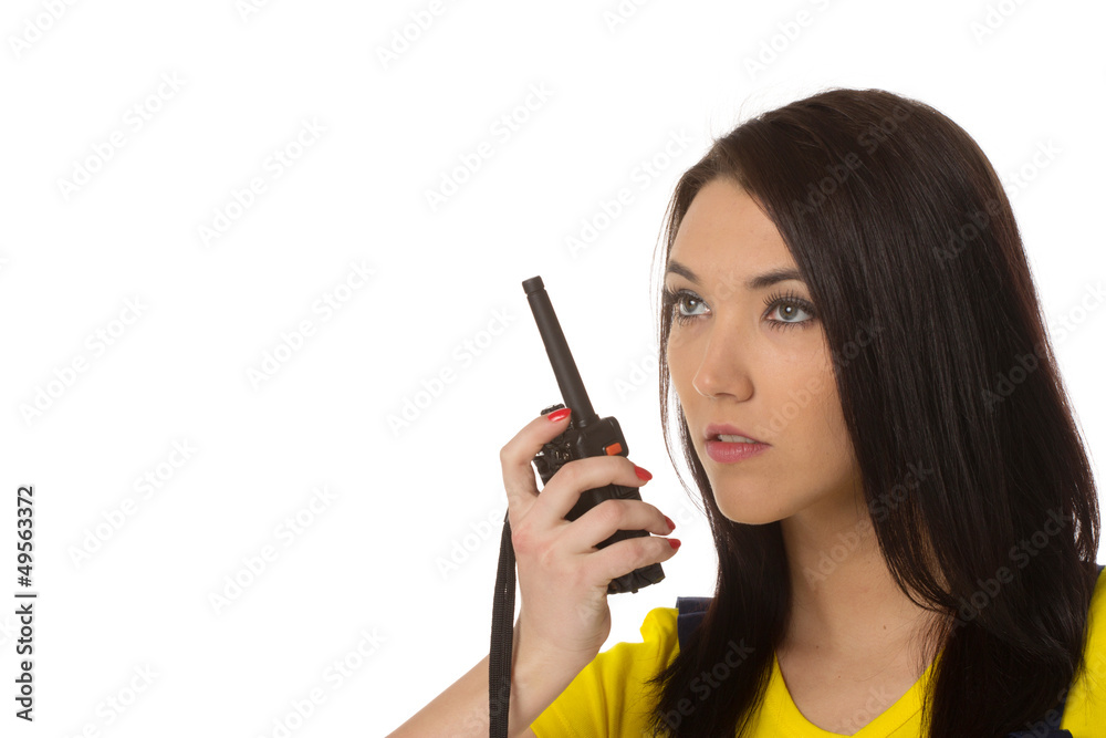 Serious female construction worker talking with a walkie talkie Serious female construction worker talking with a walkie talkie