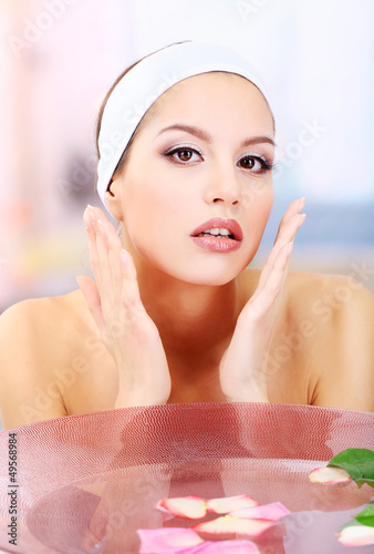 Young woman washing her fac...