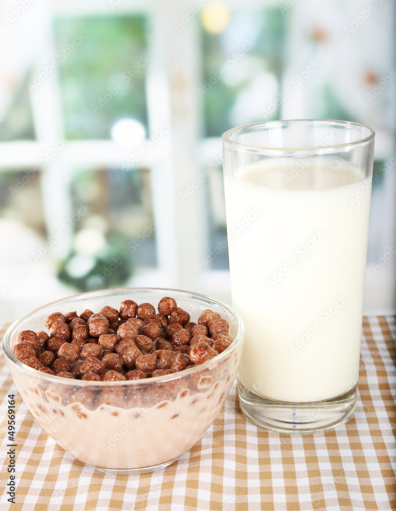 Delicious and healthy cereal in bowl with milk on table in room Delicious and healthy cereal in bowl with milk on table in room