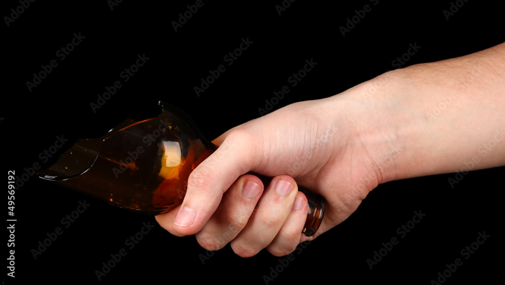 Male hand with broken glass bottle, isolated on black Male hand with broken glass bottle, isolated on black