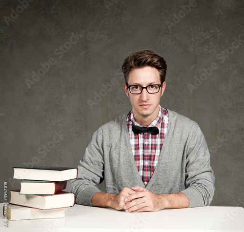 Student mit Büchern sitzt vor einer Tafel