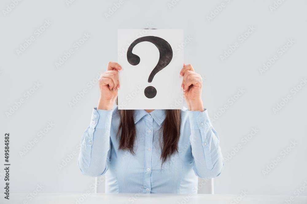 Business woman holding question mark signboard paper in front of Business woman holding question mark signboard paper in front of