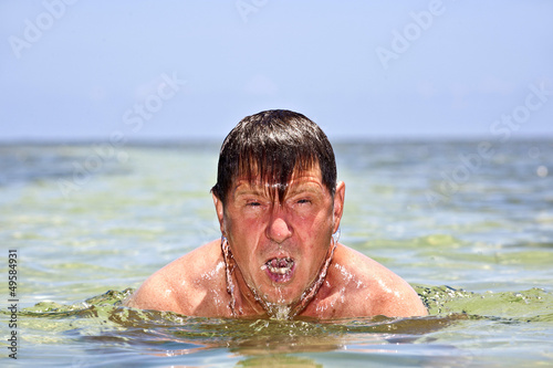 portrait of a man swimming in the crystal clear ocean