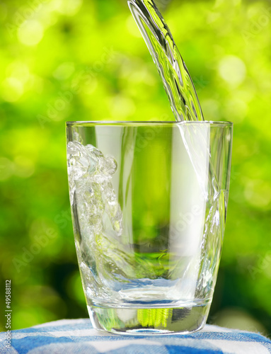 Glass of water on nature background