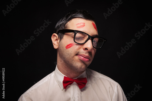 Funny portrait of young nerd with kiss imprints blinking eye 