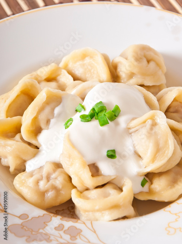 Russian national ravioli with sour cream on a plate