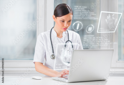 Pretty female medicine doctor working with modern computer inter