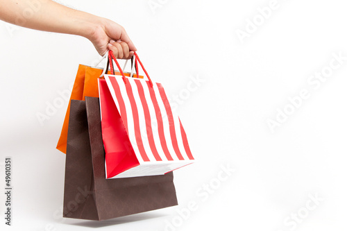 Holding shoping bags by hand on white isolate