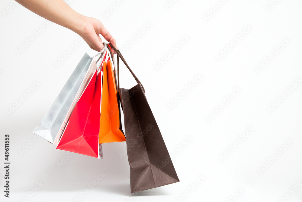 Holding shoping bags by hand on white isolate
