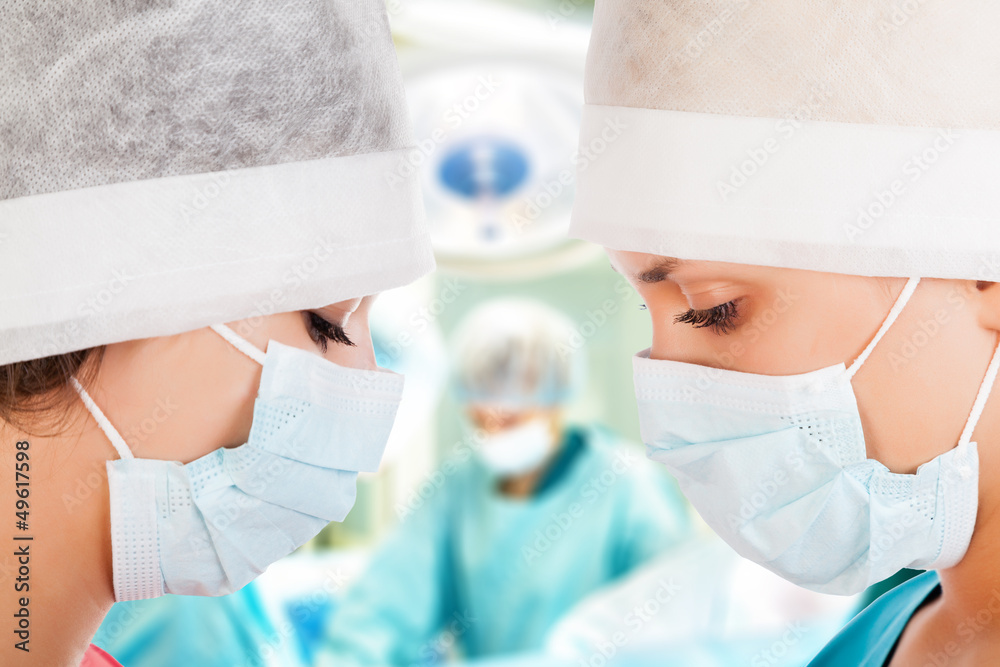 Fototapeta premium Two female surgeon with nurse in operation room