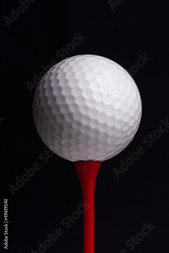 golf tees with ball on black background