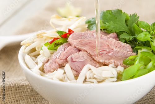 Pho Bo - Vietnamese rice noodle soup with beef, herbs and chili