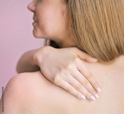 Woman with hand on shoulder. Focus is on a hand