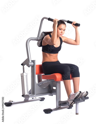 sporty woman doing exercises on gym equipment
