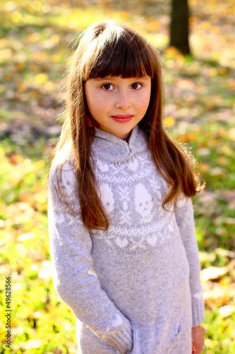 Portrait of little girl in a gray dress outdoors