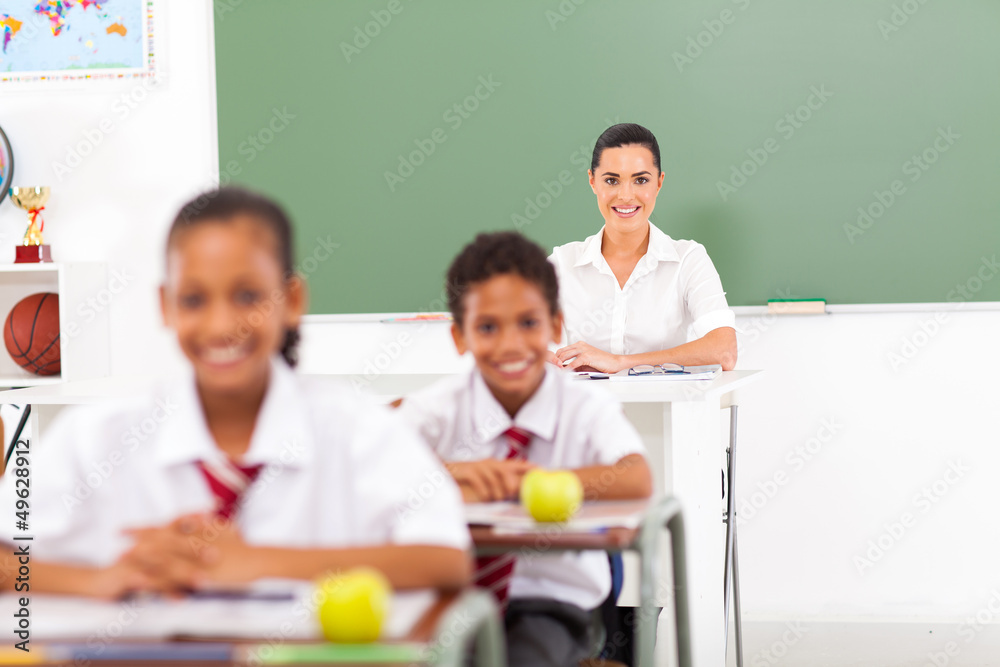 pretty female school teacher in classroom with students pretty female school teacher in classroom with students