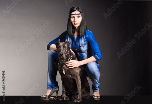 Beautiful woman in jeans clothes sitting next to the dog