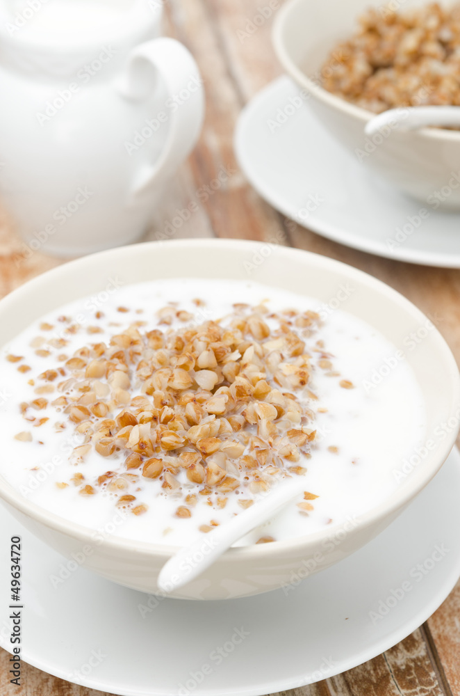 Boiled buckwheat with milk in a white bowl, closeup Boiled buckwheat with milk in a white bowl, closeup