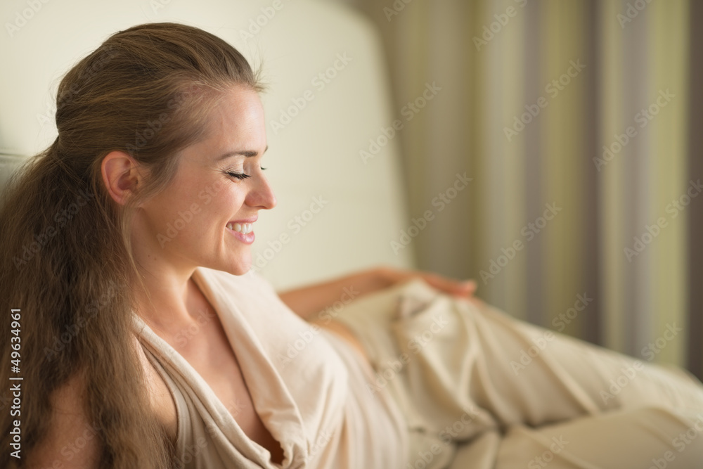 Smiling young woman laying on sofa Smiling young woman laying on sofa