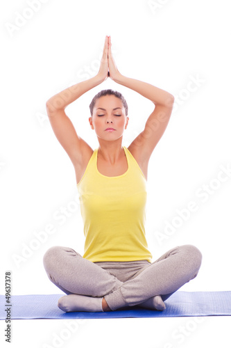 Portrait of a young girl meditating isolated on white