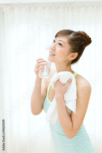 Beautiful young woman drinking water at workout
