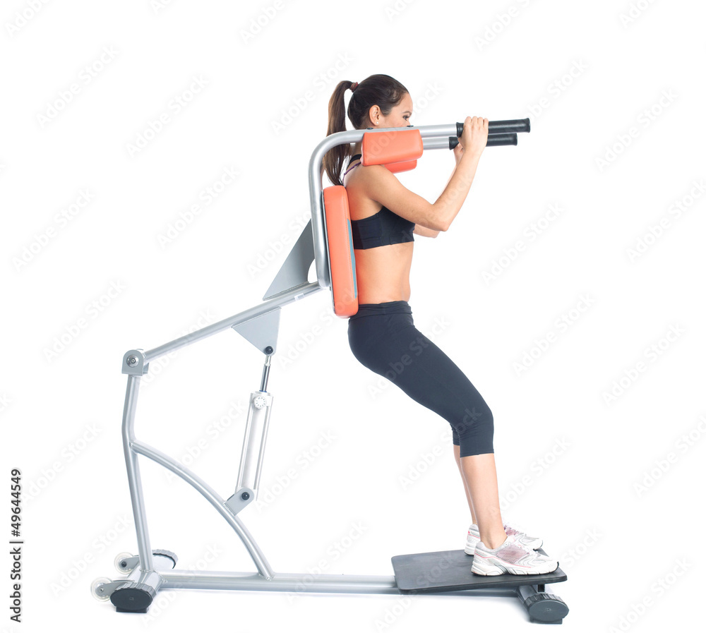 Fototapeta premium Beautiful slim woman trains on exerciser