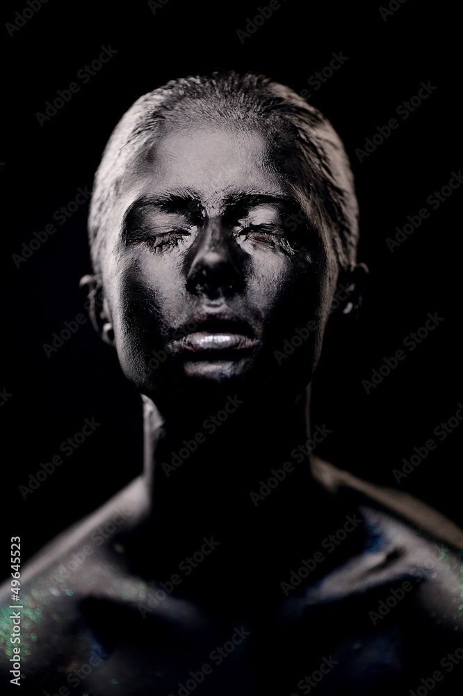 girl in black paint on dark background