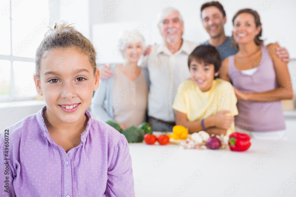 Fototapeta premium Young girl standing beside kitchen counter