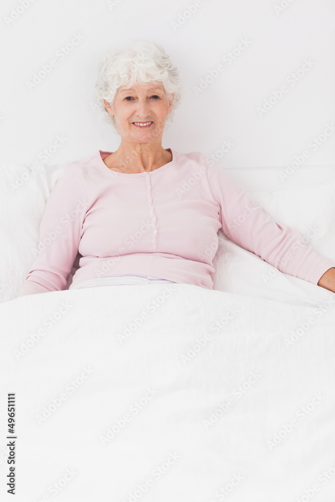 Smiling woman sitting in bed