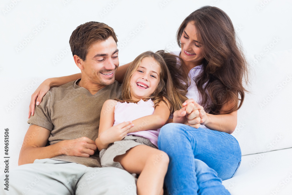 Smiling family playing together on a sofa Smiling family playing together on a sofa