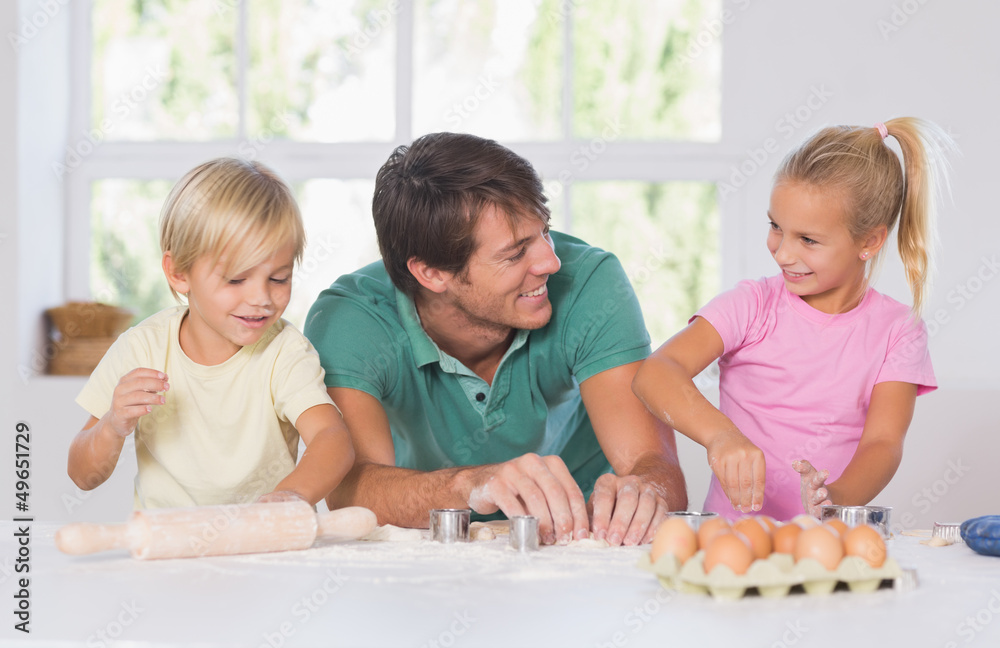 Father and his children cutting cookies out Father and his children cutting cookies out