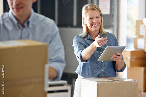Manager Using Tablet Computer In Distribution Warehouse