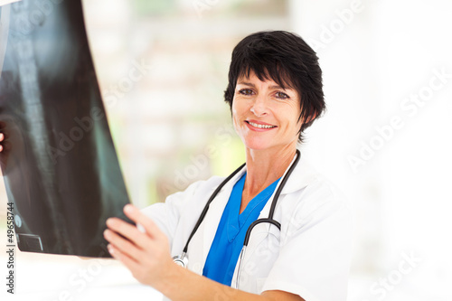 pretty middle aged medical doctor looking at x-ray