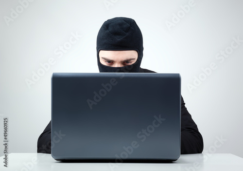 Hacker stealing information from a computer at the desk