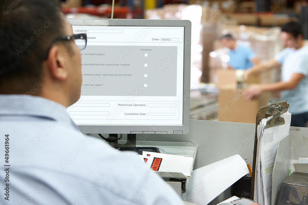 Person At Computer Terminal In Distribution Warehouse Person At Computer Terminal In Distribution Warehouse