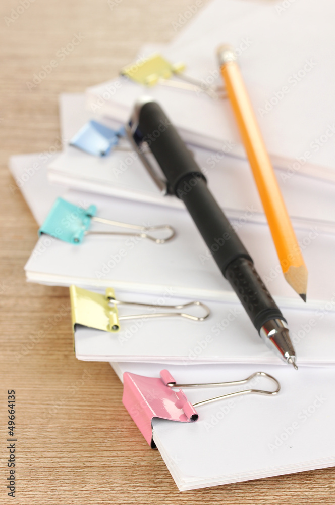 Documents with binder clips on wooden table Documents with binder clips on wooden table