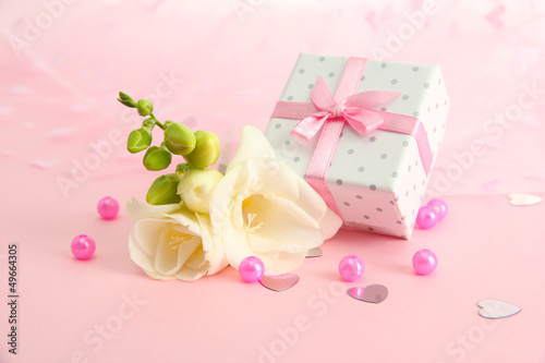 Beautiful romantic gift box and flower on pink background