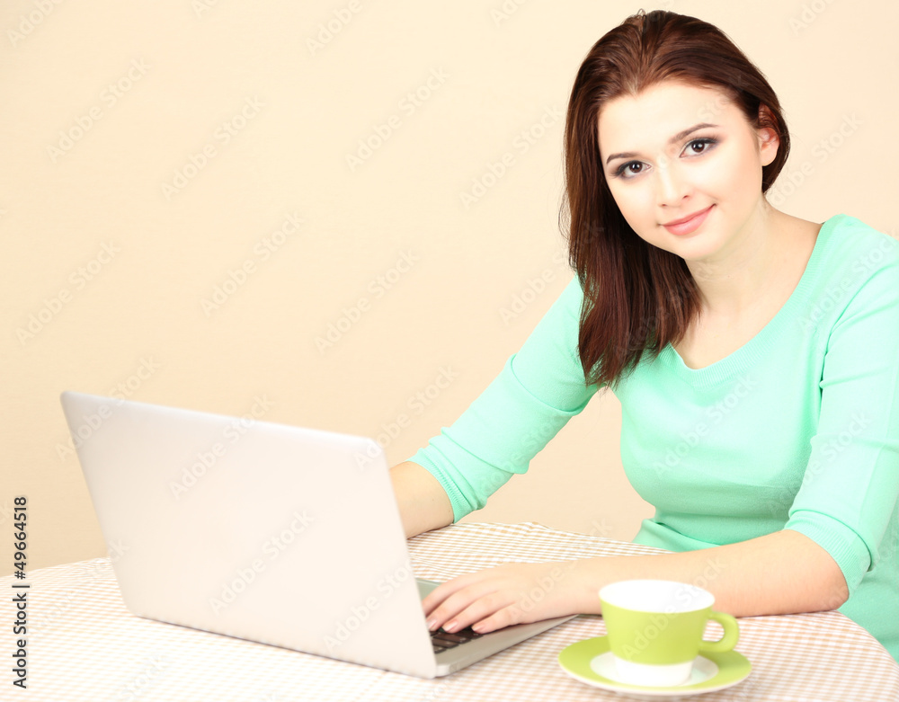 Beautiful young woman working on laptop on light background Beautiful young woman working on laptop on light background