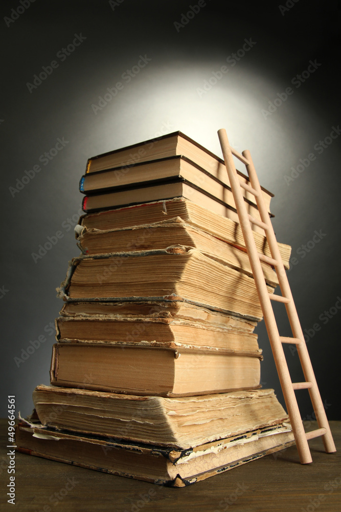 Old books and wooden ladder, on grey background Old books and wooden ladder, on grey background