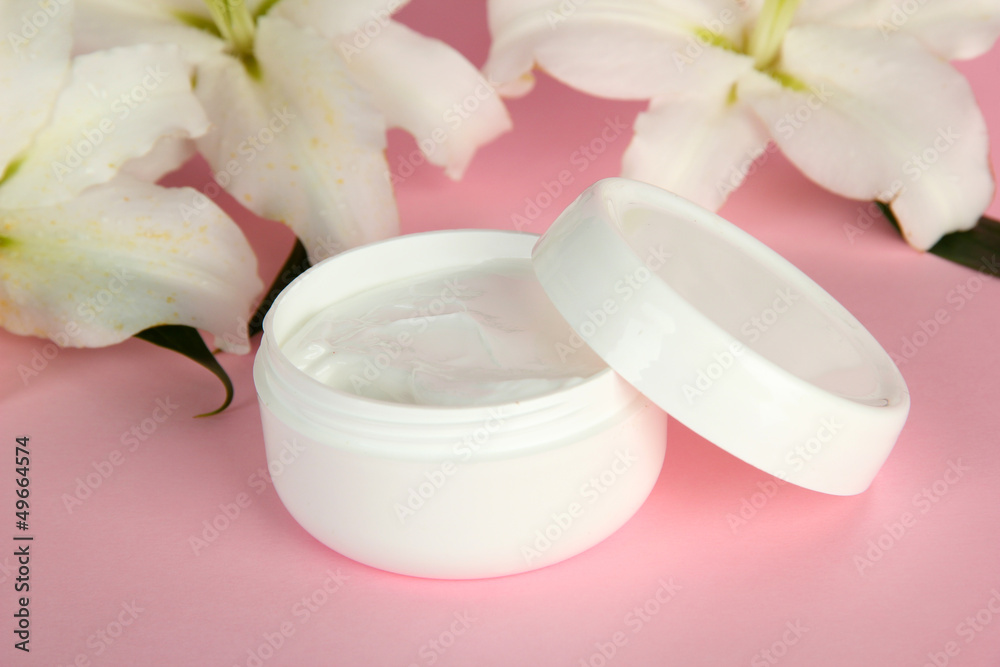 Cosmetic cream and beautiful lily, on pink background