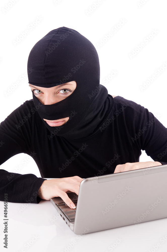 Hacker with computer wearing balaclava Hacker with computer wearing balaclava