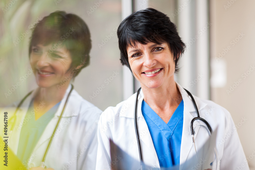 middle aged medical worker with x-ray standing by window middle aged medical worker with x-ray standing by window