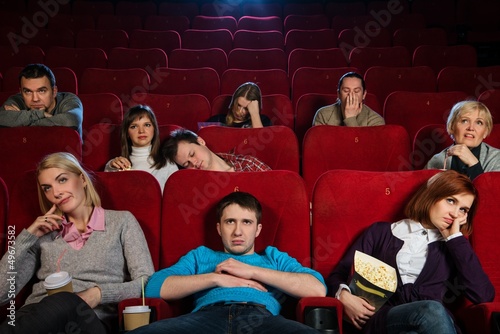 Group of boring people watching movie in cinema