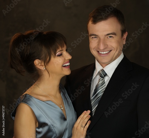 Young well-dressed smiling man and woman in evening dress
