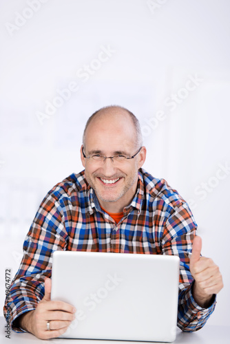 mann mit laptop zeigt daumen hoch