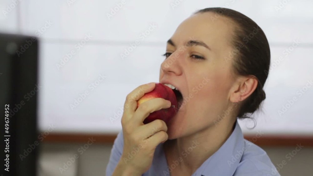 Young businesswoman eating red apple, slow motion Young businesswoman eating red apple, slow motion